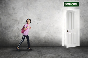 Obraz premium Elementary student running toward a door