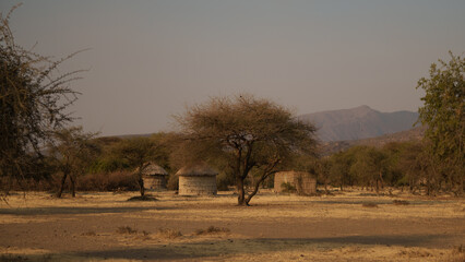 Scenic view of a maasai village with traditional huts in the vast savanna landscape of tanzania,...