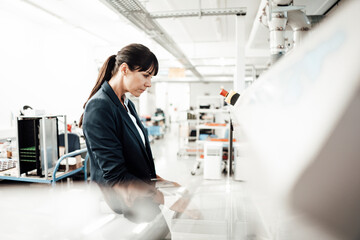 Businesswoman using computer at industry