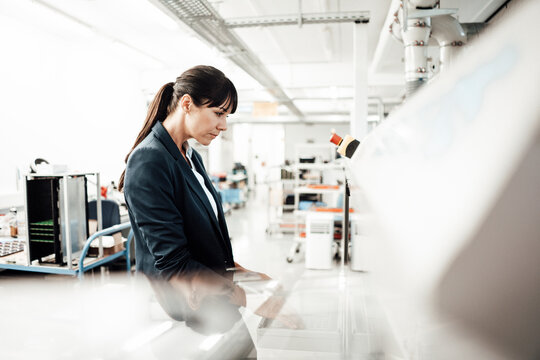 Businesswoman using computer at industry