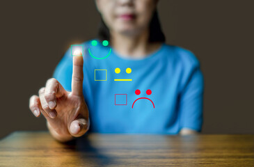Close up woman hand show the smile face emoticon on the virtual touch screen , Customer service and business satisfaction survey.