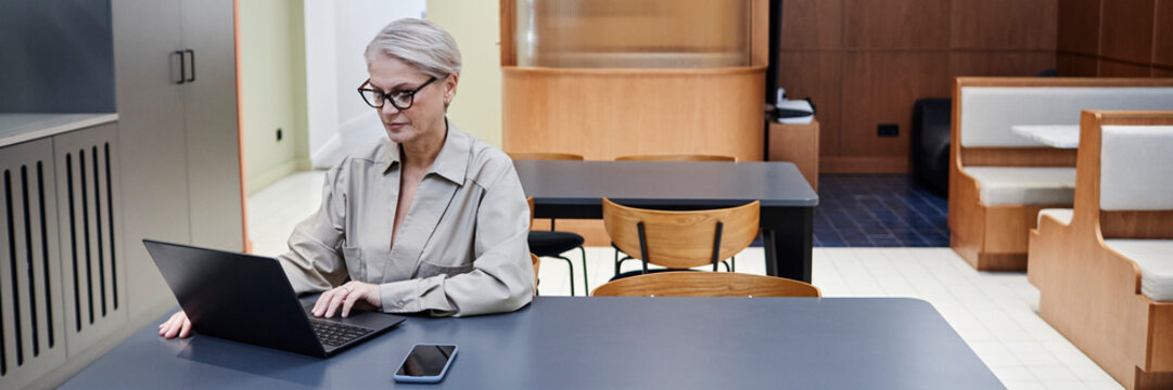 Businesswoman working on a laptop in a modern office setting