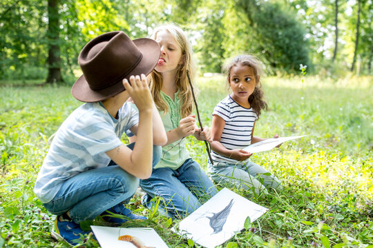 Boy and girl having an argument in nature, girl sticking out tongue