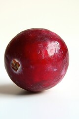Obraz premium Close up of a vibrant red cranberry with a smooth surface and a light background in a studio shot
