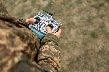Drone control panel is in hand of military soldier. Artillery spotter or military observer launches...