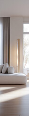 a minimalist living room featuring a soft white sectional, smooth natural wood flooring, and a tall standing lamp with warm lighting