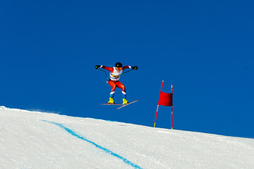 ski racer perform jumping during competitive downhill skiing
