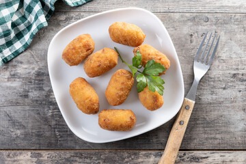 Fried cod croquettes on wooden table