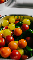A bowl of assorted fruits including tomatoes, peppers, and green beans. The bowl is filled with a variety of colors and textures, creating a vibrant and healthy-looking display