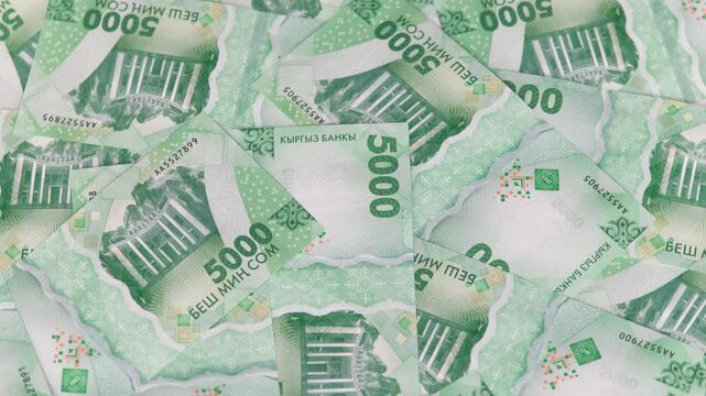 rotating background of new 5000 Kyrgyzstani Som banknotes, closeup full-frame loopable background