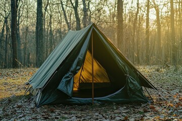 A dark green tent is open in a serene forest clearing