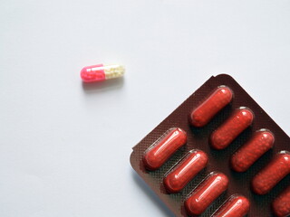 Red and pink pills on white background