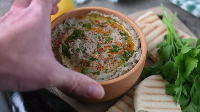 Traditional baba ganoush in bowl on wooden table