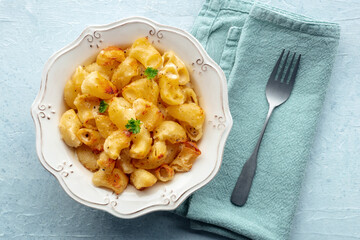Mac and cheese, the classic pasta with macaroni and Cheddar cheese, garnished with parsley, overhead flat lay shot