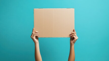 Hands holding blank cardboard sign against teal background