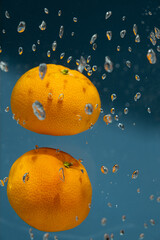 Underwater view of fresh tangerines with bubbles