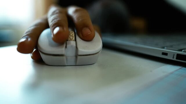 Close-Up of Hand Using White Computer Mouse, Close-up of a hand using a white computer mouse on a desk