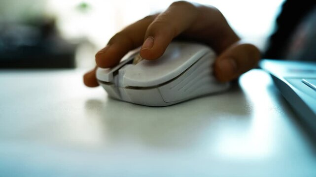 Close-Up of Hand Using White Computer Mouse, Close-up of a hand using a white computer mouse on a desk