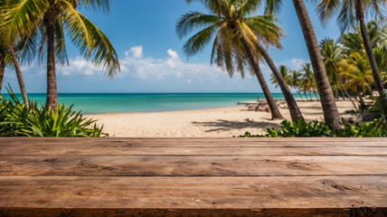Empty wooden table on blurred background of sunny beach with palm trees on sea shore
