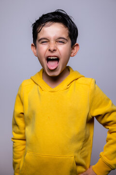 Excited child in yellow hoodie expressing emotions