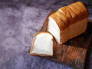 A stack of  white bread slices against, Bread Sliced on Wooden Cutting Board,Top view