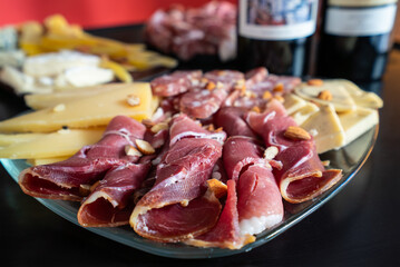 A plate of meat and cheese with a black background