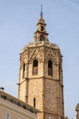 Valencia Cathedral and Miguelete Tower (Micalet) from Plaza de la Reina, Spain. A Gothic masterpiece standing tall, framed by the lively ambiance of one of Valencia’s most iconic squares.