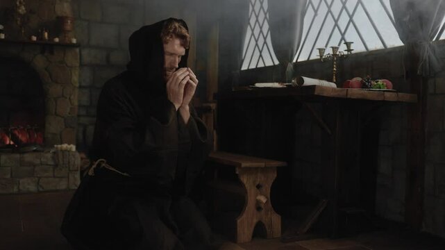 Solitary desperate priest kneeling before church altar in mystical smoke