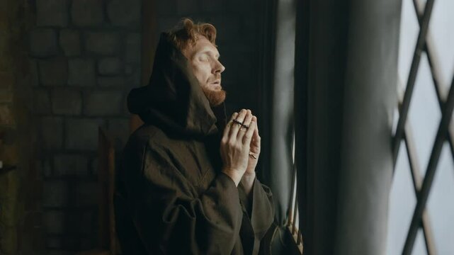 Thoughtful medieval monk praying in cathedral