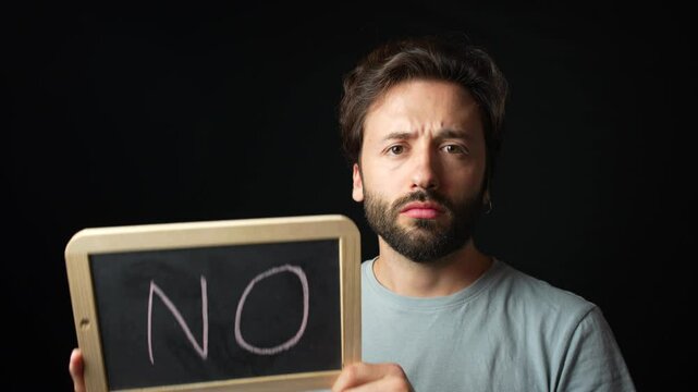 Sad caucasian Man holding a Chalkboard with the Handwritten word  "no"