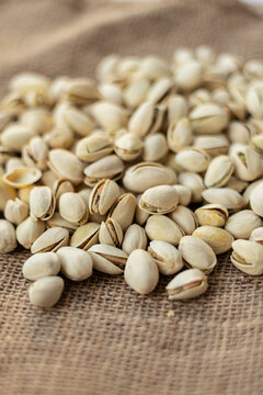 Close up of scattered pistachios over a burlap surface