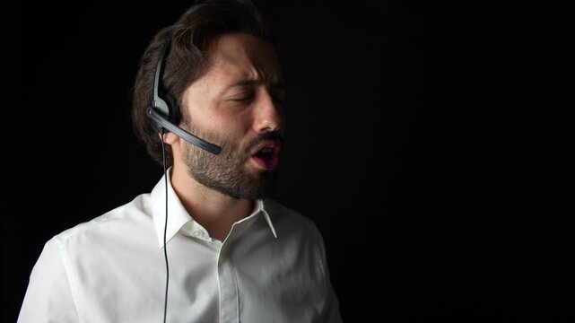 Call center operator wearing a white shirt speaking, with a headset on, focused on a conversation.
