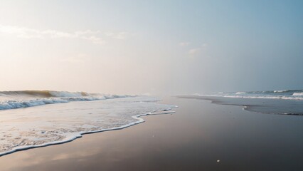 Obraz premium Serene beach scene with soft waves and misty horizon