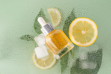 Citrus essence with ice and lemon on dewy surface
