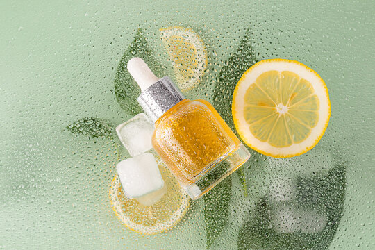 Citrus essence with ice and lemon on dewy surface