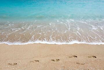 Wave on the beach and footprint