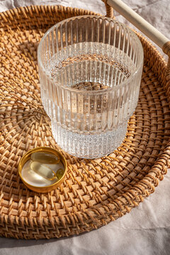 Omega 3 and vitamin D3 supplements on rattan tray with water