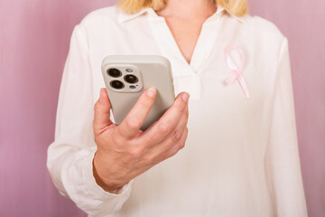 Woman Holding Smartphone with Breast Cancer Awareness Ribbon