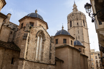 Obraz premium Valencia Cathedral and Miguelete Tower (Micalet) from Plaza de la Reina, Spain. A Gothic masterpiece standing tall, framed by the lively ambiance of one of Valencia’s most iconic squares.