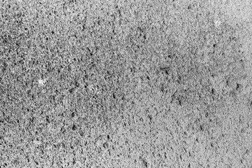 Close view of a weathered concrete surface displaying various textures and patterns formed by erosion.