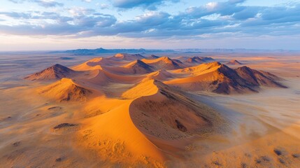 Fototapeta premium Aerial view of sunrise over sculpted sand dunes in the Namib Desert