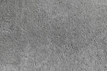 Detailed concrete surface shows cracks and texture under bright daylight, highlighting aging and wear.