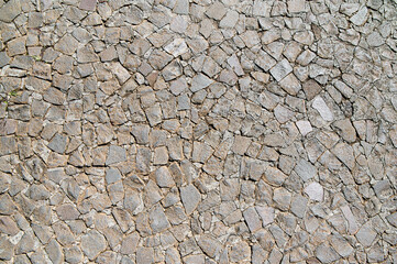 Close-up view of a textured wall made from various irregular stones, showcasing a unique pattern and natural beauty.