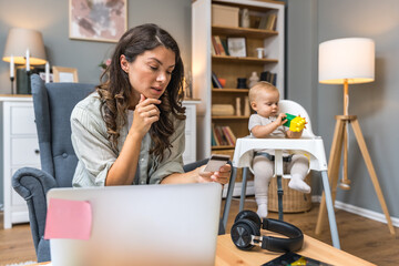 Young woman, mother and business woman, sitting at home online shopping with credit card on laptop...
