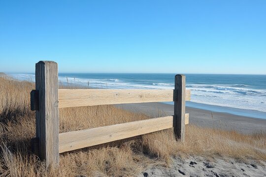 Scenic coastline with wooden fence overlooking ocean and sandy beach on a clear sunny day