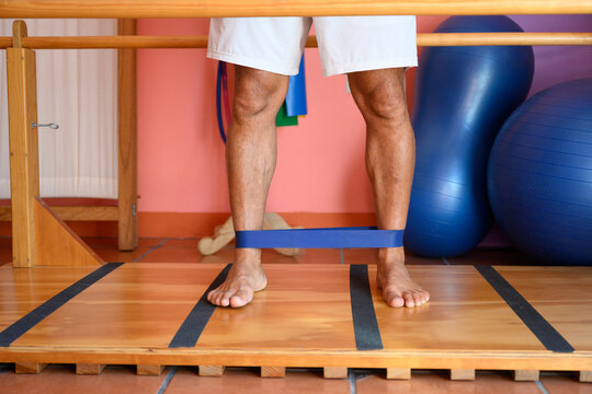 Patient performing ankle exercises with resistance band in rehabilitation center