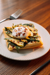 waffles with poached egg avocado on plate on wooden background