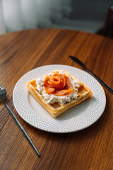 Belgian waffles with salmon on wooden background, breakfast, red fish