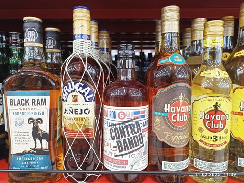 Diverse rum and whiskey bottles on shelf in liquor store display