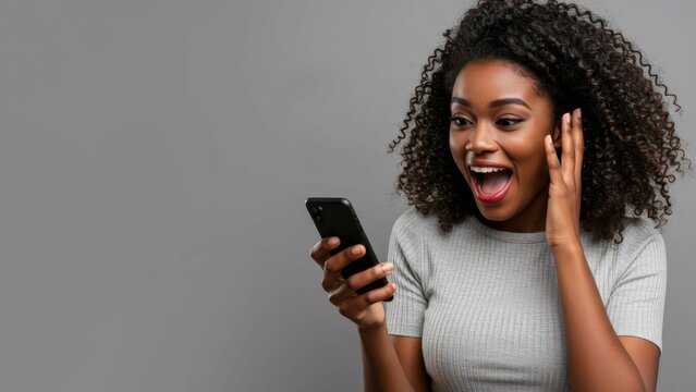 Wow, news and excited black woman with phone in studio for online competition giveaway on grey background. Yes, smartphone and happy female model with app notification of sign ups winner or prize - Powered by Adobe